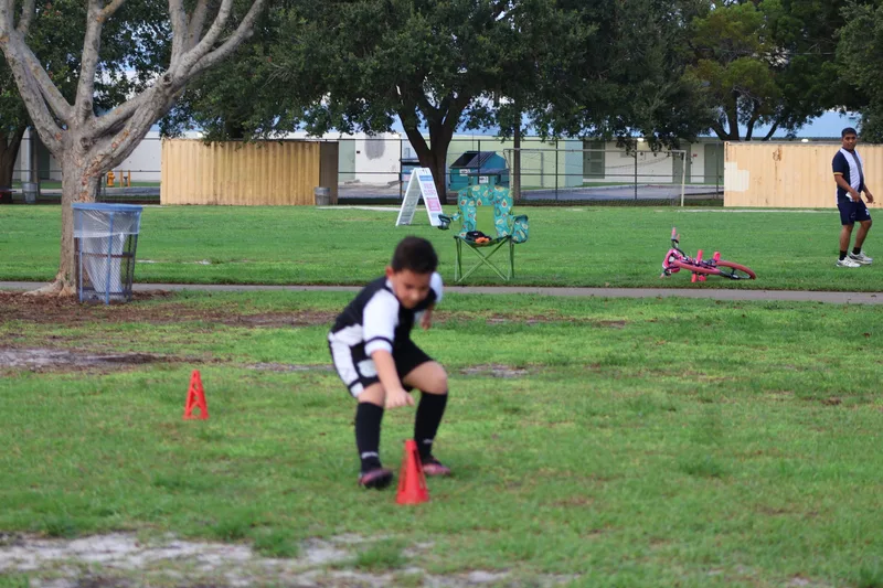 A young player runs between red training cones