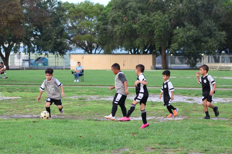 A group of young players follows a teammate with the ball