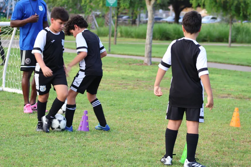 Teammates practice close ball control around cones