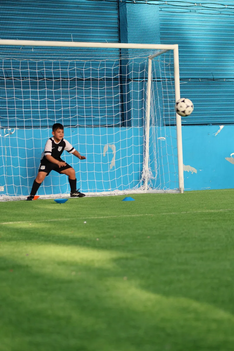 A goalkeeper sets his stance in front of the goal